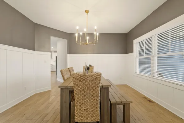 a dining room with furniture a chandelier and wooden floor