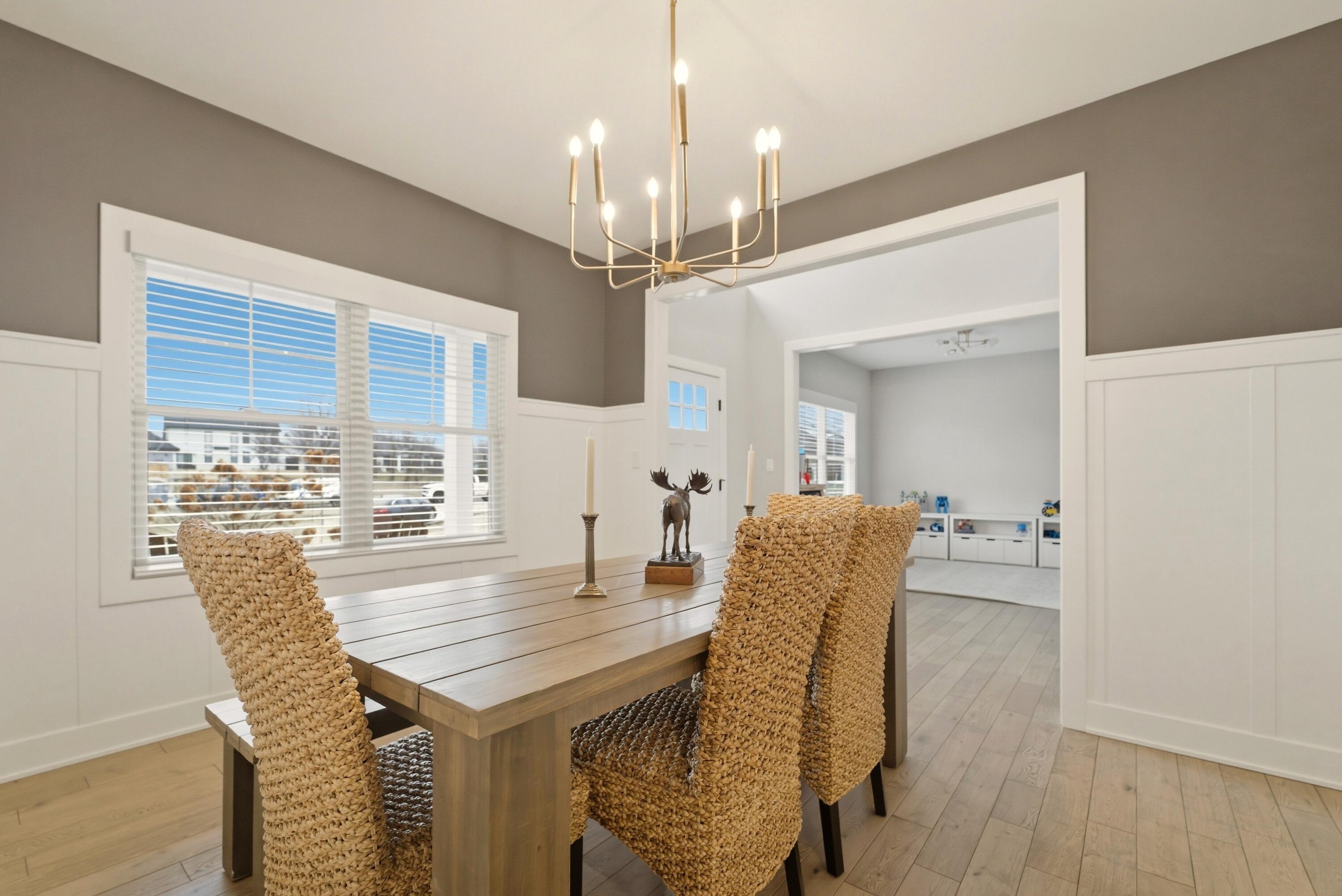 11200 Oak Ridge Court Crown Point, IN 46307 - Photo 17 of 43 a dining room with furniture a chandelier and wooden floor