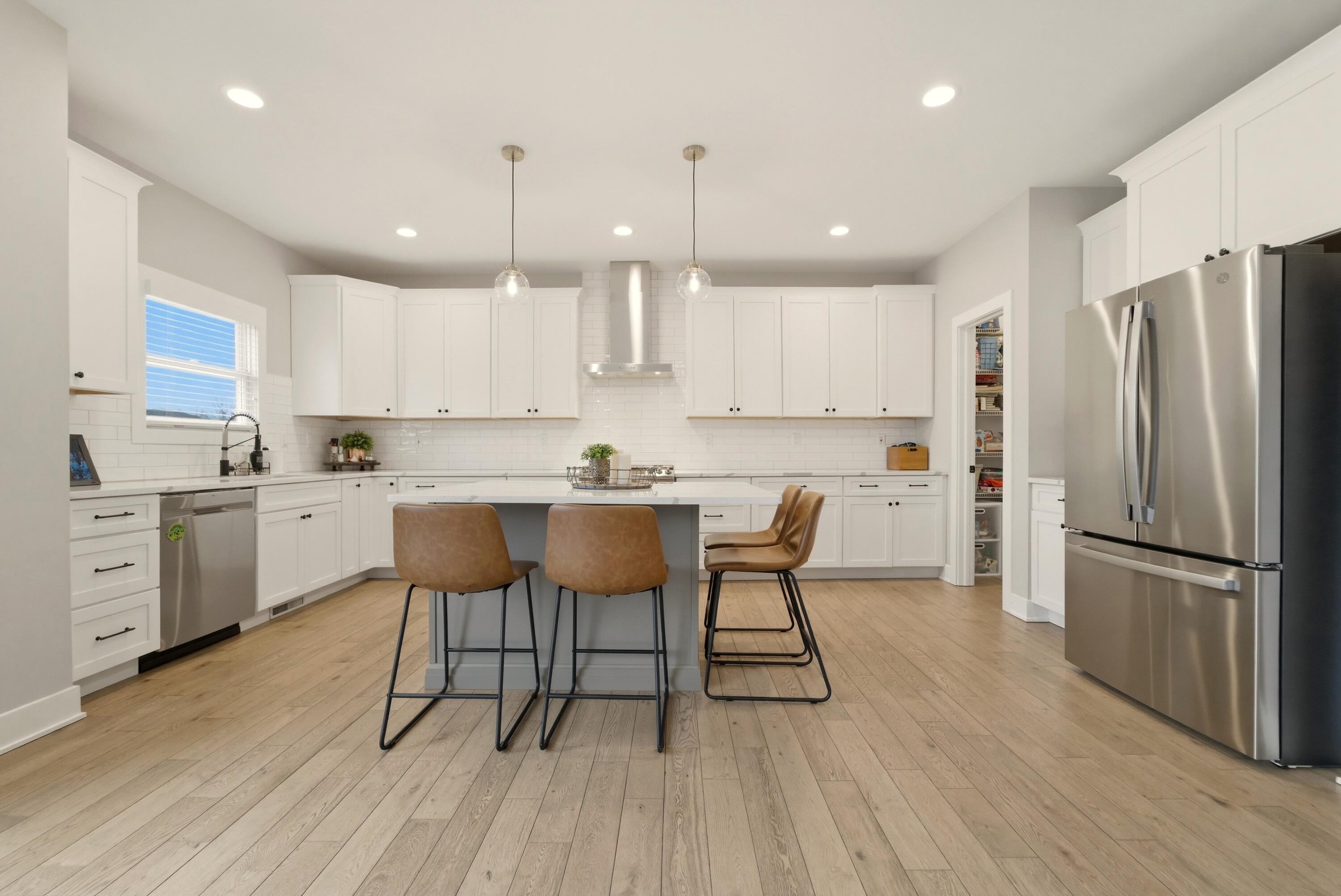 11200 Oak Ridge Court Crown Point, IN 46307 - Photo 6 of 43 a kitchen with stainless steel appliances granite countertop a refrigerator a sink dishwasher a stove and white cabinets with wooden floor