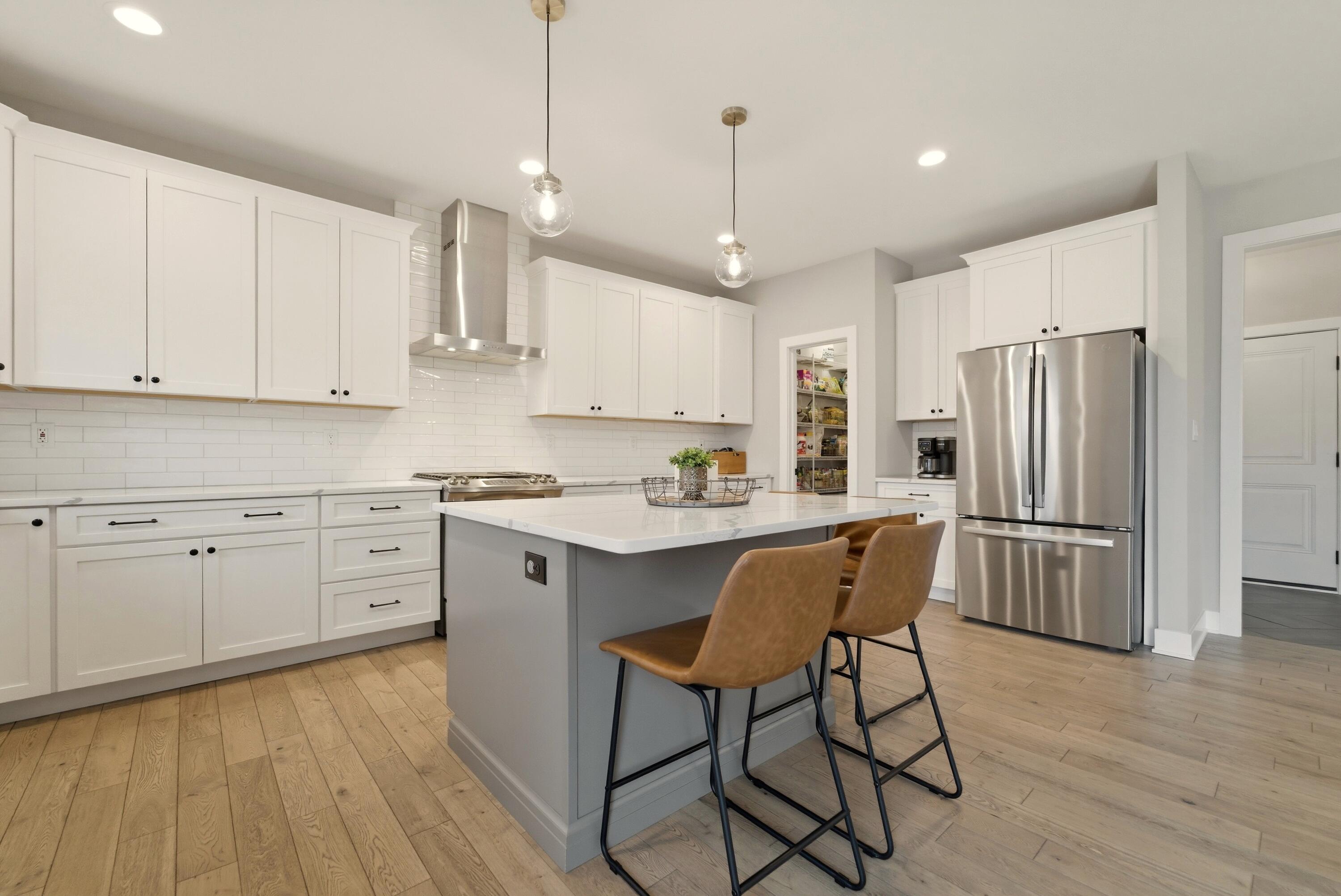 11200 Oak Ridge Court Crown Point, IN 46307 - Photo 7 of 43 a kitchen with stainless steel appliances granite countertop a refrigerator a sink dishwasher a stove and white cabinets with wooden floor