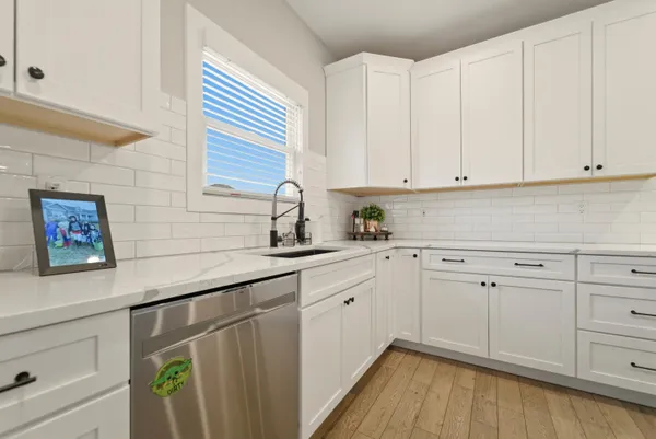 a kitchen with white cabinets and sink