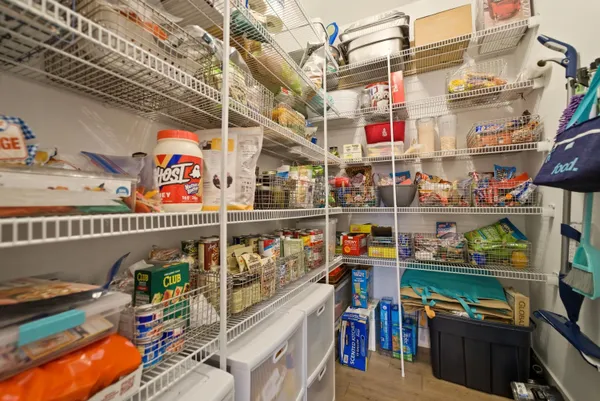 a kitchen with stainless steel appliances granite countertop a sink a stove a refrigerator and island with wooden floor