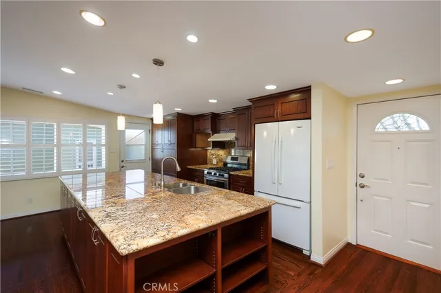 a kitchen with kitchen island a refrigerator stove microwave and cabinets