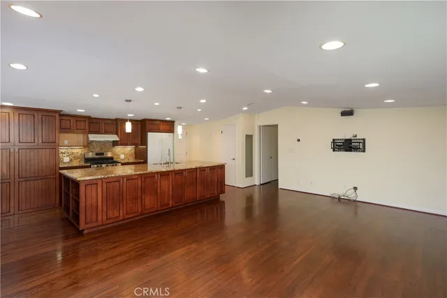 an open kitchen with a sink and a refrigerator