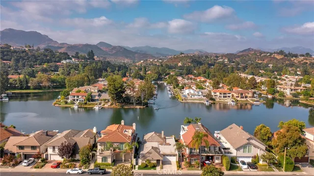 an aerial view of residential houses with outdoor space and lake view