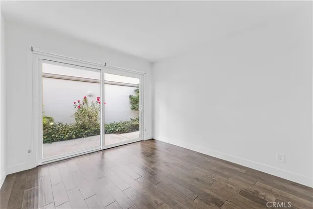an empty room with wooden floor and window