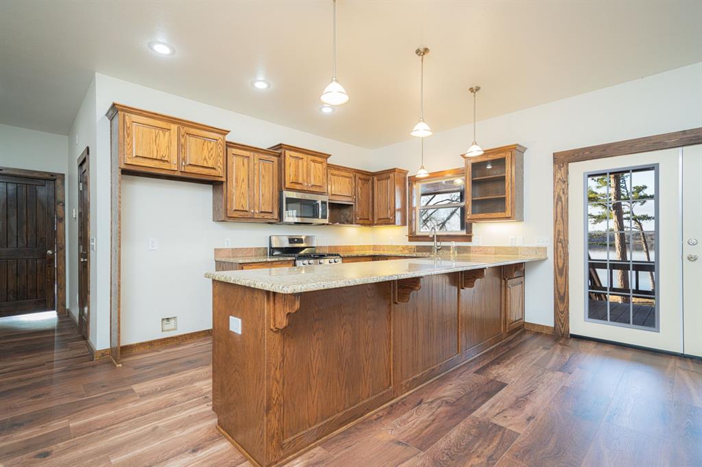 410 Private Road Leesburg, TX 75451 - Photo 12 of 38 a kitchen with stainless steel appliances granite countertop a sink stove and wooden floor
