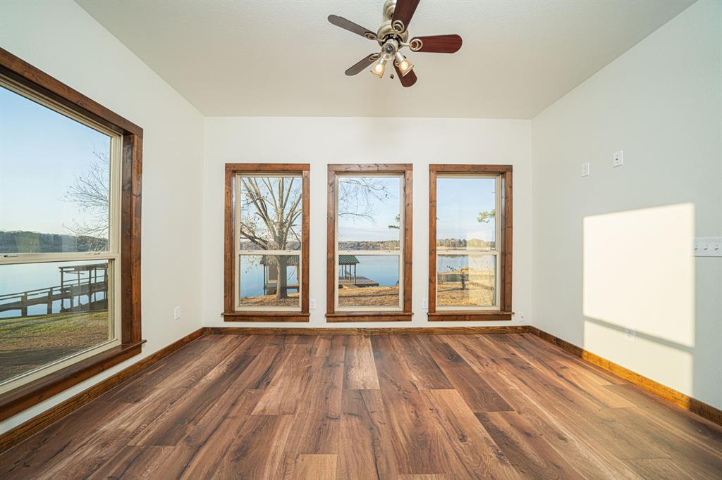410 Private Road Leesburg, TX 75451 - Photo 15 of 38 a view of an empty room with wooden floor and a window
