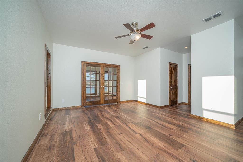 410 Private Road Leesburg, TX 75451 - Photo 16 of 38 a view of an empty room with wooden floor and a window