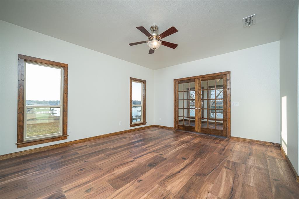 410 Private Road Leesburg, TX 75451 - Photo 17 of 38 a view of an empty room with a window and wooden floor