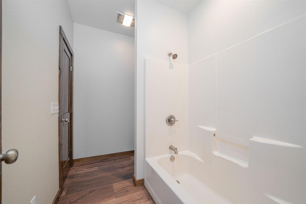 410 Private Road Leesburg, TX 75451 - Photo 21 of 38 a bathroom with a tub and shower