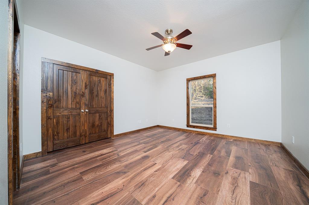 410 Private Road Leesburg, TX 75451 - Photo 23 of 38 a view of an empty room with wooden floor and window