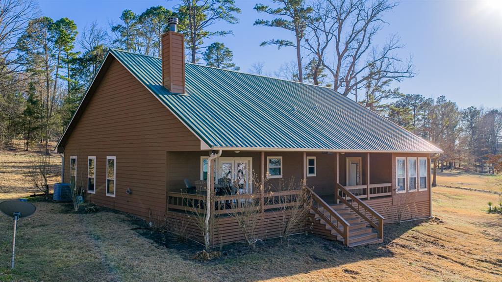 410 Private Road Leesburg, TX 75451 - Photo 30 of 38 a view of a house with a yard and wooden deck