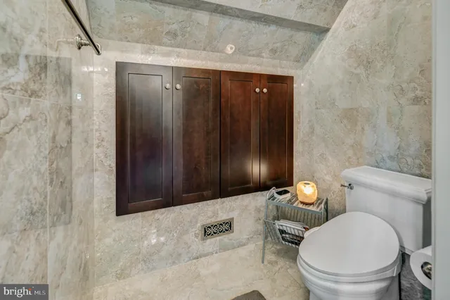 a bathroom with a granite countertop sink a toilet and shower