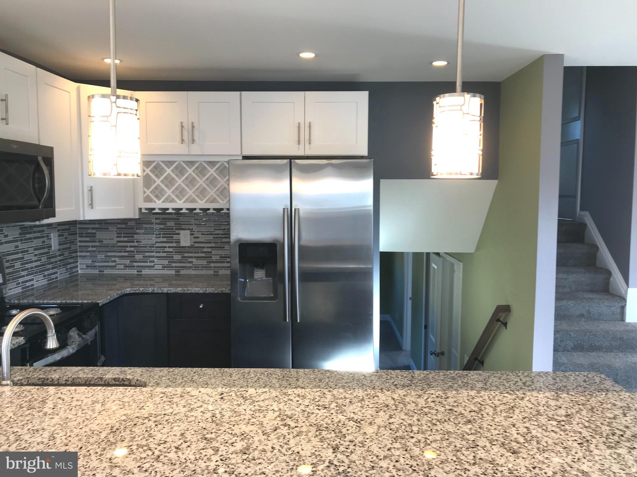 7806 Selgrave Road Baltimore, MD 21244 - Photo 11 of 25 a kitchen with stainless steel appliances kitchen island granite countertop a refrigerator a sink a stove and oven