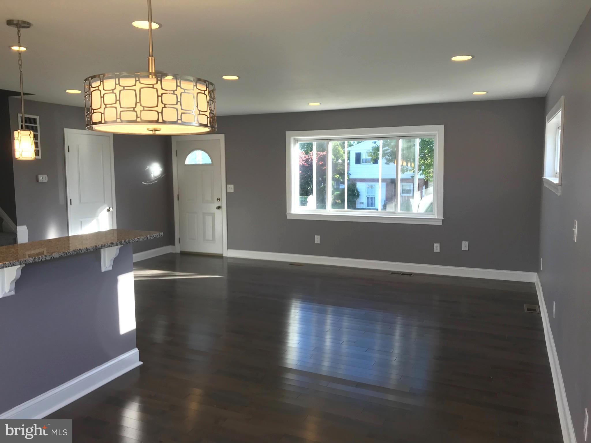 7806 Selgrave Road Baltimore, MD 21244 - Photo 8 of 25 an open space with wooden floor and chandelier