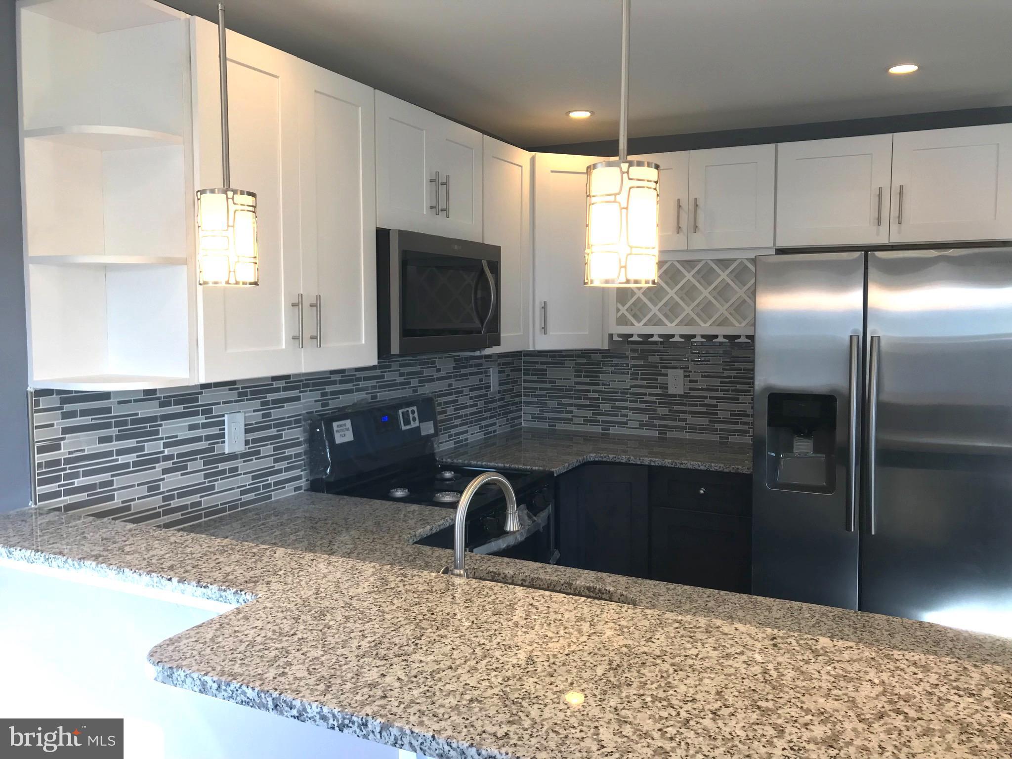 7806 Selgrave Road Baltimore, MD 21244 - Photo 10 of 25 a kitchen with kitchen island granite countertop a sink stainless steel appliances and cabinets