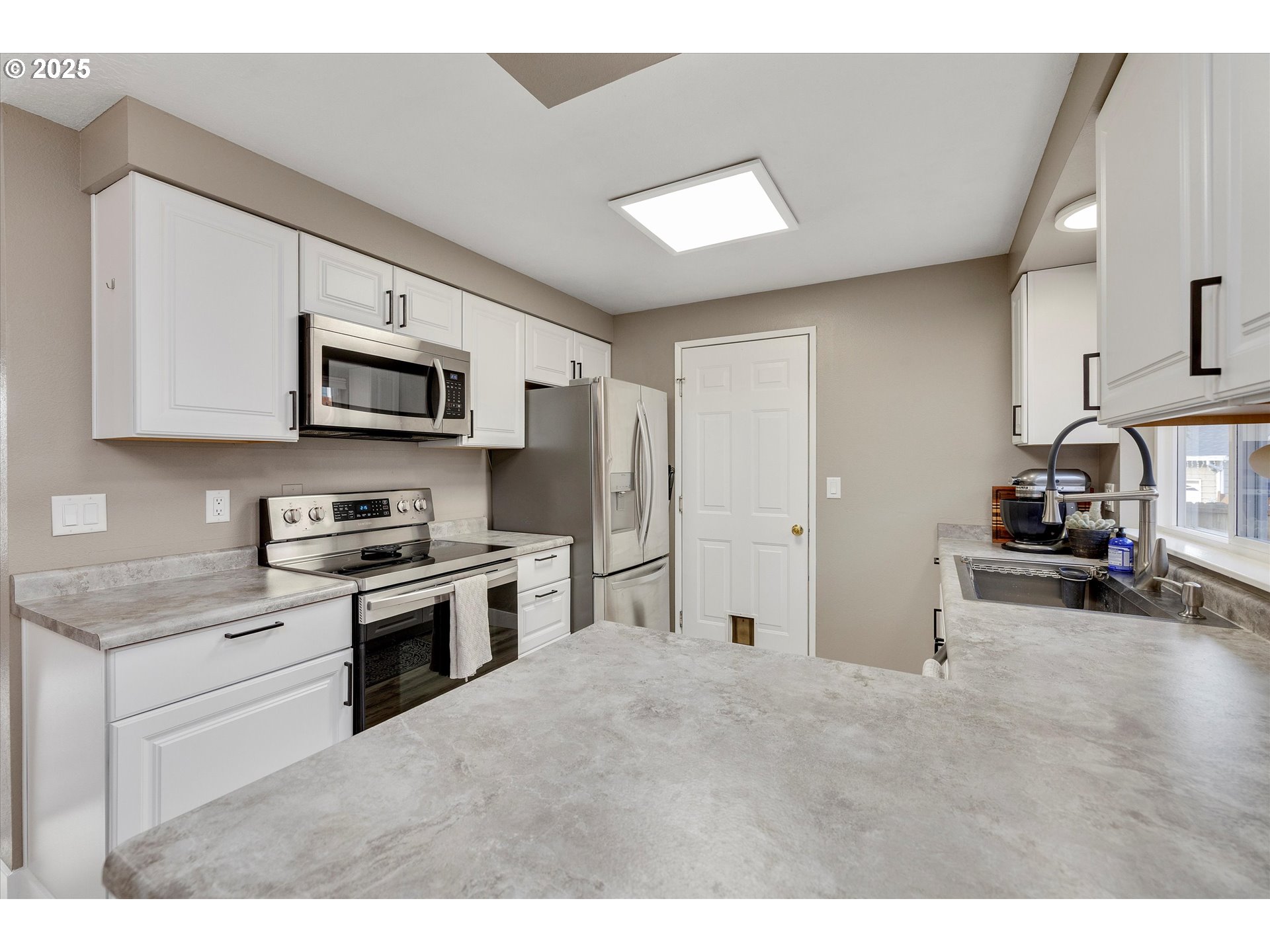 2389 F Street Hubbard, OR 97032 - Photo 11 of 34 a kitchen with kitchen island a stove top oven a sink dishwasher and a refrigerator with wooden floor