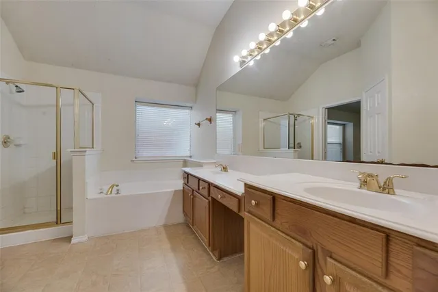 a spacious bathroom with a granite countertop sink mirror and a bathtub