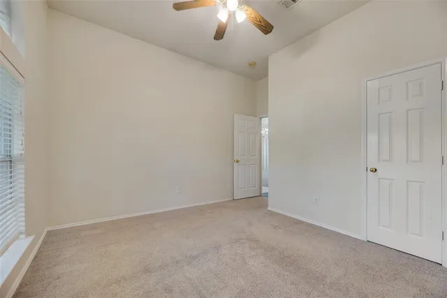 an empty room with a chandelier fan
