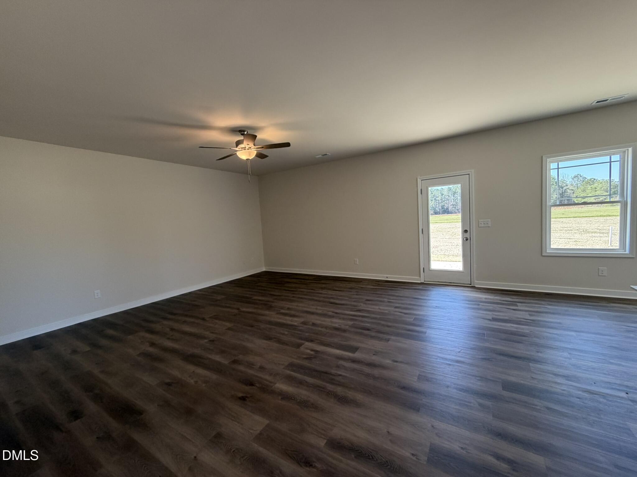 159 Jacobs Ridge Drive Four Oaks, NC 27524 - Photo 2 of 18 an empty room with wooden floor chandelier fan and windows