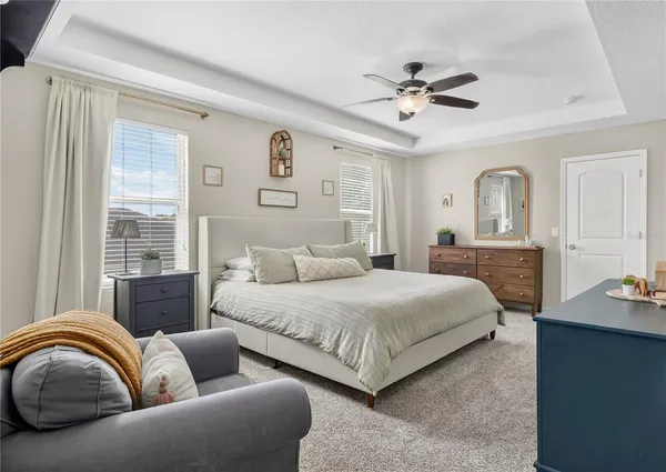 a spacious bedroom with a bed couch and window