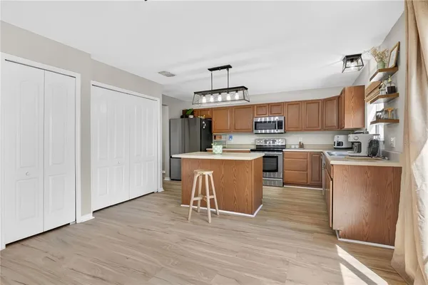 a kitchen with stainless steel appliances granite countertop a stove top oven a sink and a refrigerator