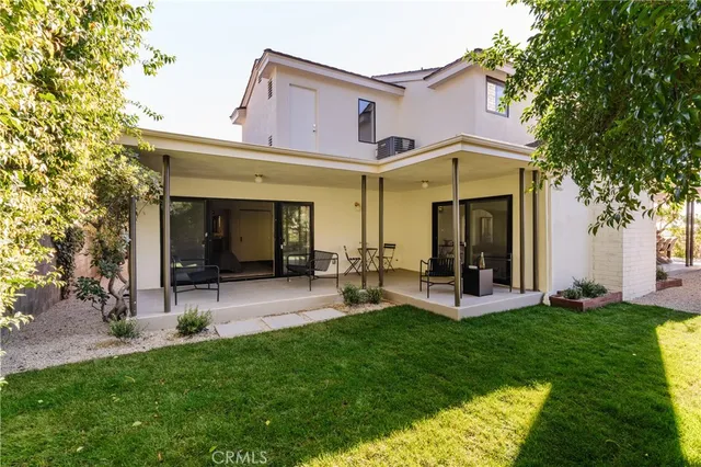 a front view of a house with patio and garden