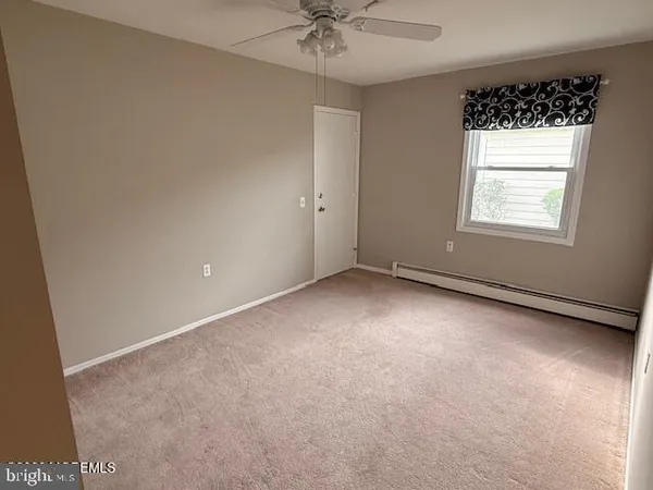 an empty room with a ceiling fan and a window