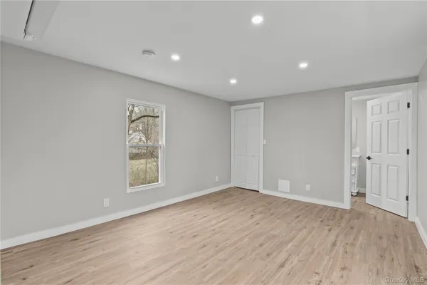 an empty room with wooden floor and window