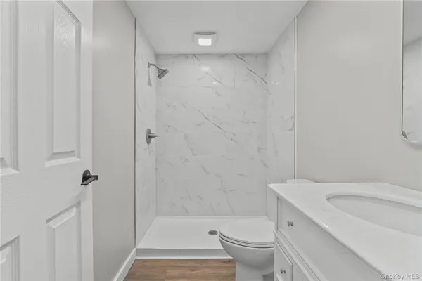 a bathroom with a shower a toilet and a sink