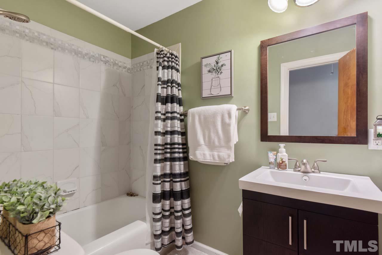 2702 Richwood Road Durham, NC 27705 - Photo 16 of 31 a bathroom with a bathtub sink vanity and a shower