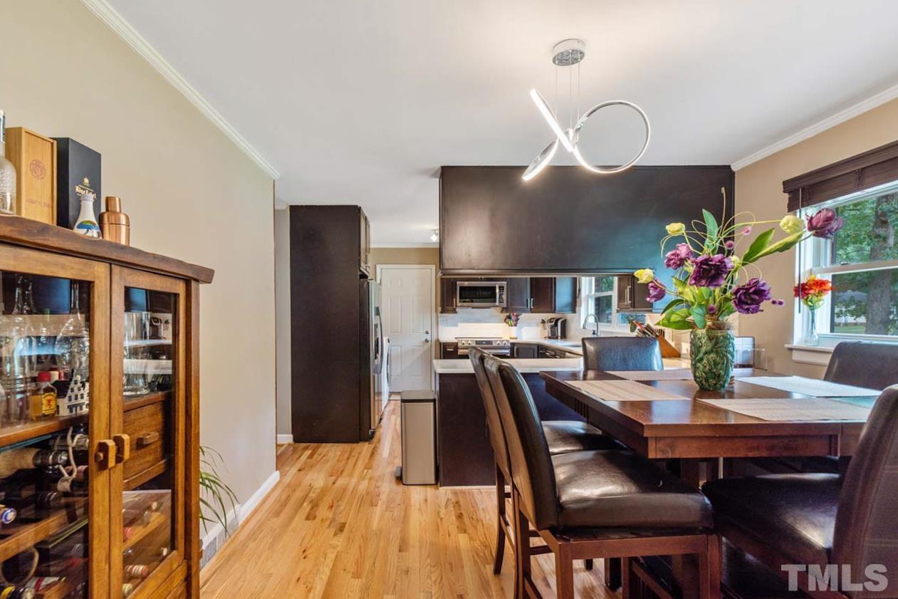 2702 Richwood Road Durham, NC 27705 - Photo 3 of 31 a dining room with furniture potted plants and wooden floor