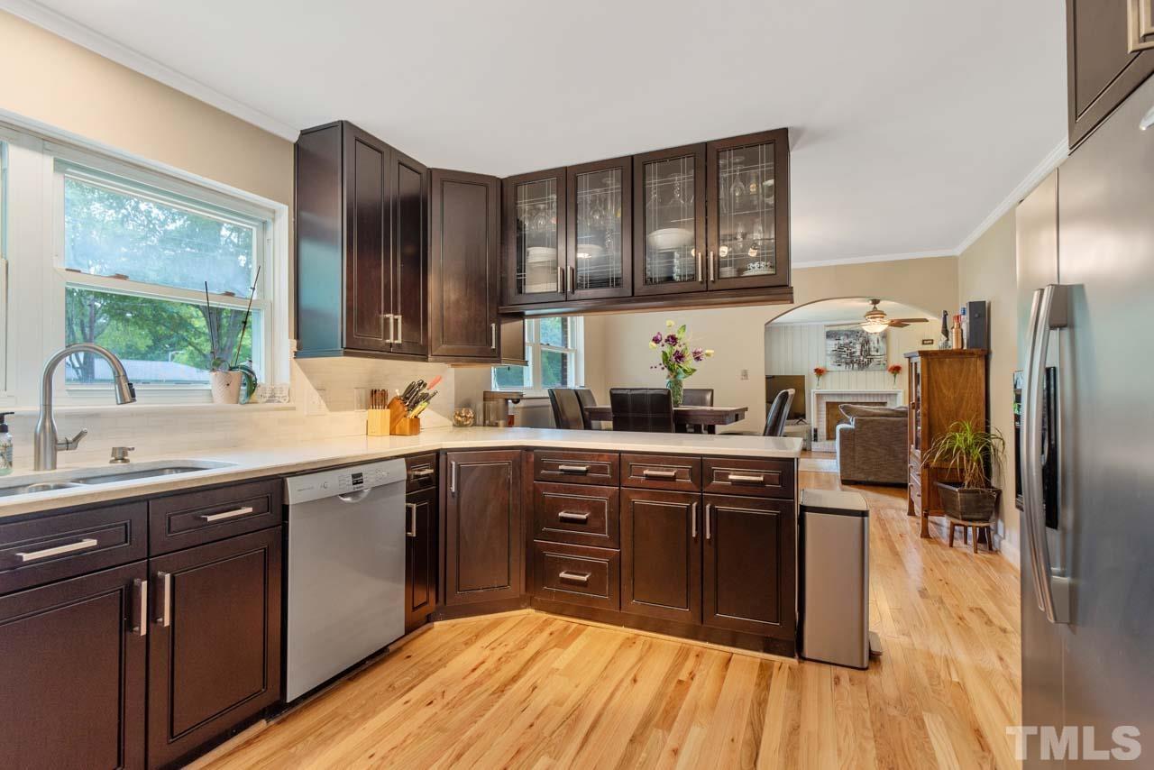 2702 Richwood Road Durham, NC 27705 - Photo 8 of 31 a kitchen with stainless steel appliances granite countertop a sink cabinets and wooden floor