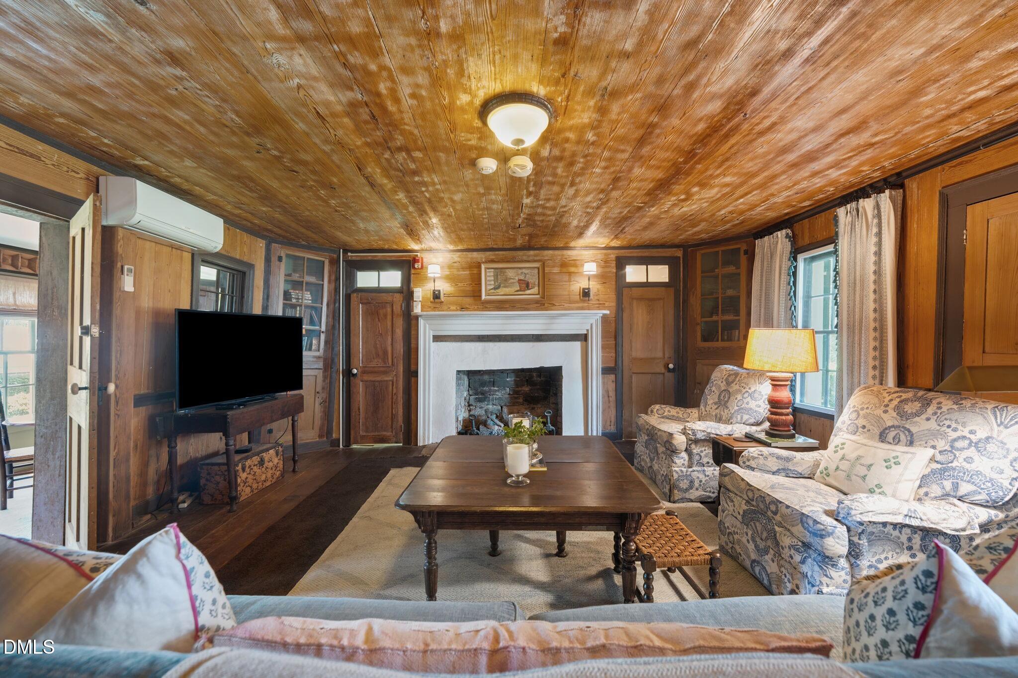 6720 Mebane Oaks Road Mebane, NC 27302 - Photo 32 of 85 a living room with furniture a flat screen tv and a fireplace