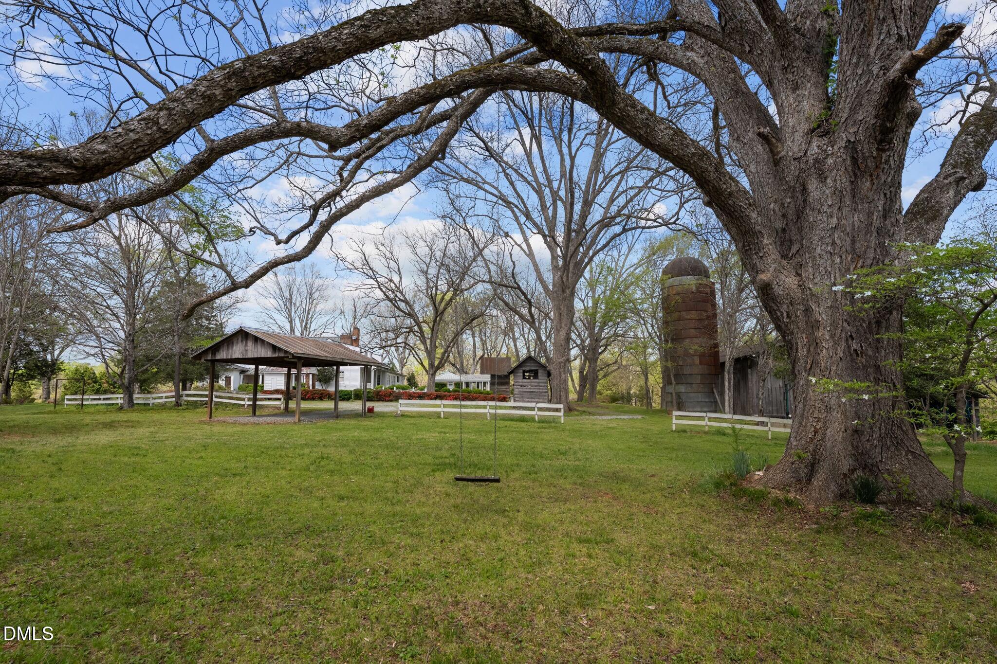 6720 Mebane Oaks Road Mebane, NC 27302 - Photo 74 of 85 a backyard of a house with outdoor seating and trees