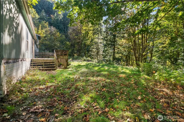 a backyard of a house with barbeque oven and trees