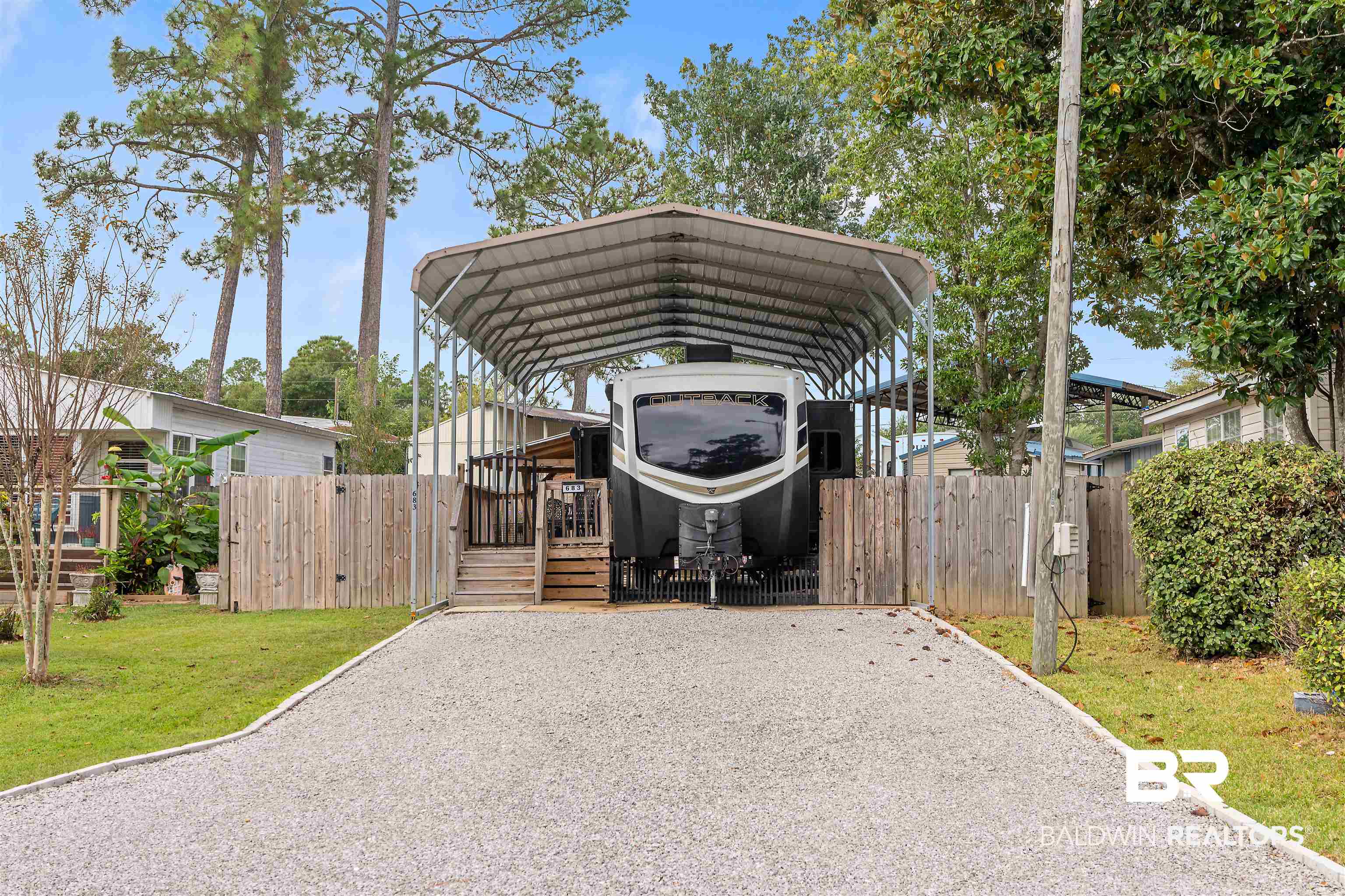 683 Escambia Loop Lillian, AL 36549 - Photo 1 of 27 View of parking with a lawn and a carport