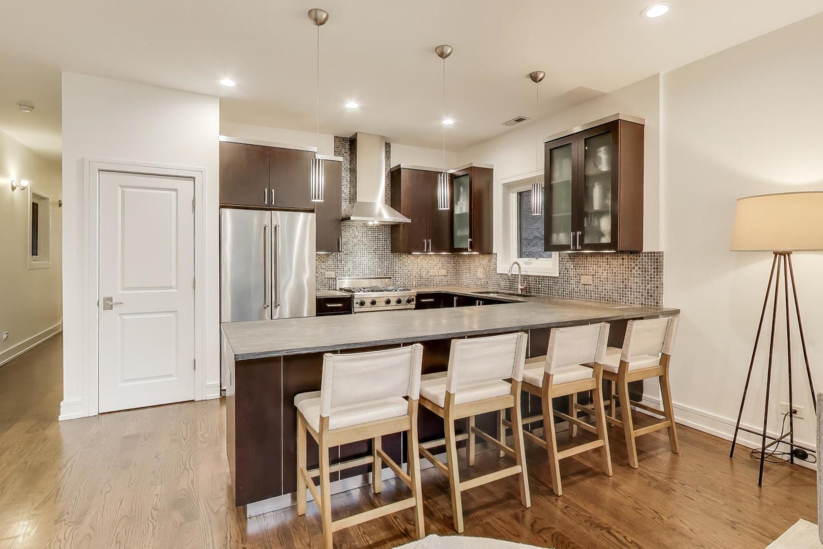 822 West Buckingham Place, Unit 301 Chicago, IL 60657 - Photo 5 of 26 a large kitchen with a table and chairs