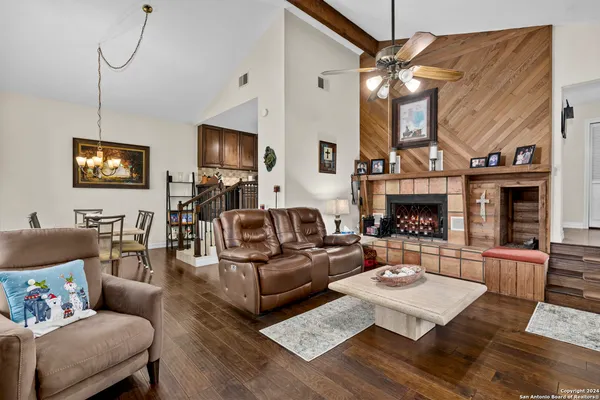a living room with furniture a flat screen tv and a fireplace