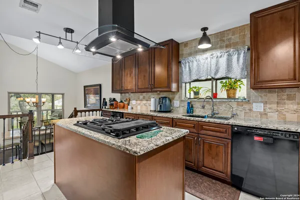 a kitchen with stainless steel appliances granite countertop a sink a stove and a wooden floors