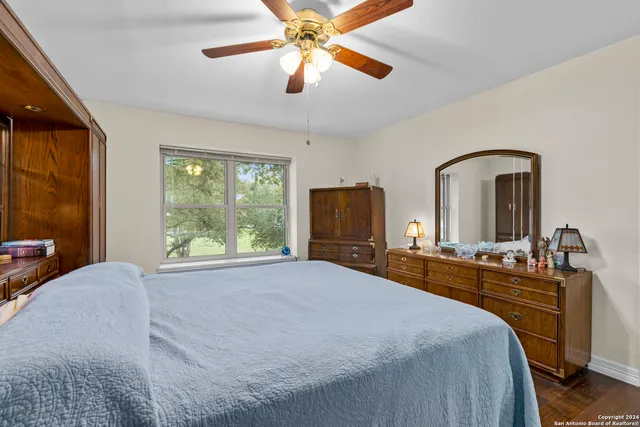 a bedroom with a bed a ceiling fan and a large window