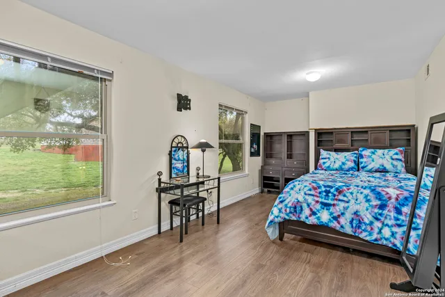 a bedroom with a bed and large windows