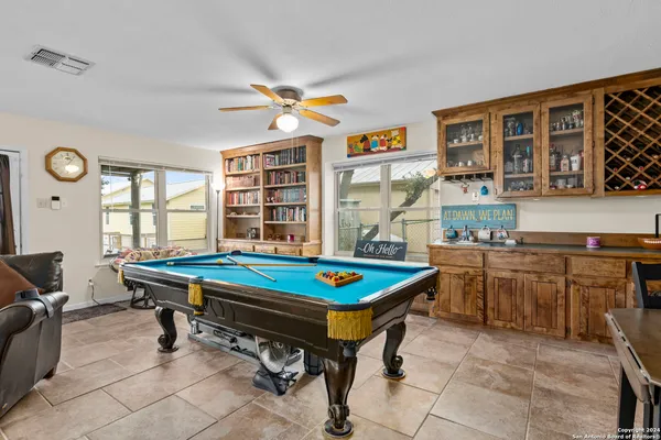 a room with furniture pool table and window