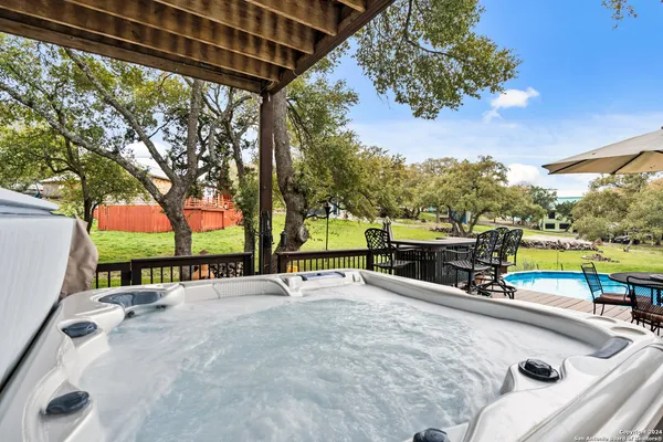 a view of a swimming pool with a patio and a backyard