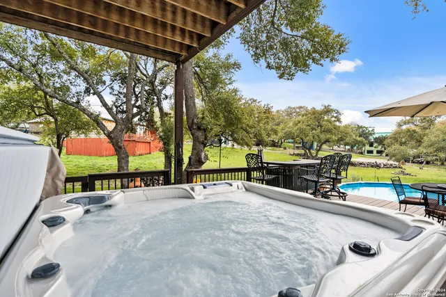 a view of a swimming pool with a patio and a backyard