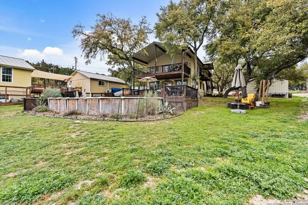a view of a house with a big yard and large tree
