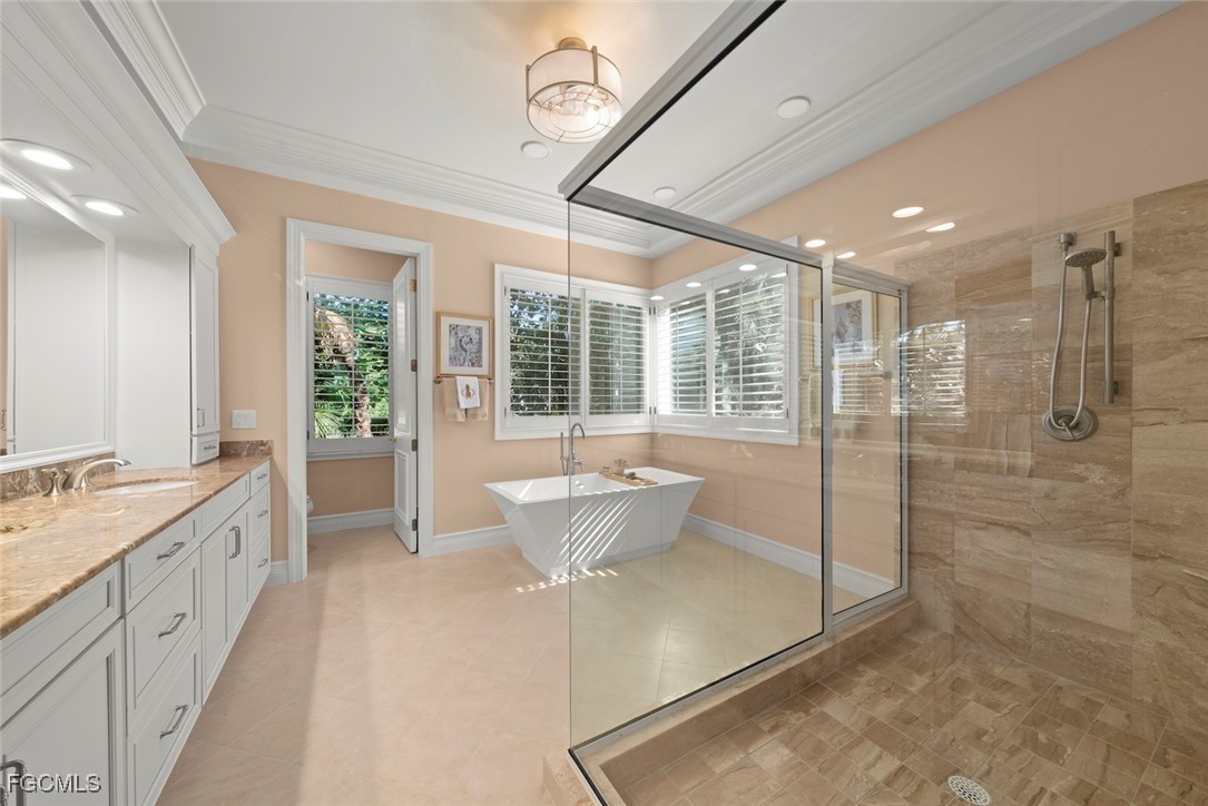 2417 Wulfert Road Sanibel, FL 33957 - Photo 17 of 50 a spacious bathroom with a granite countertop sink a large mirror and shower