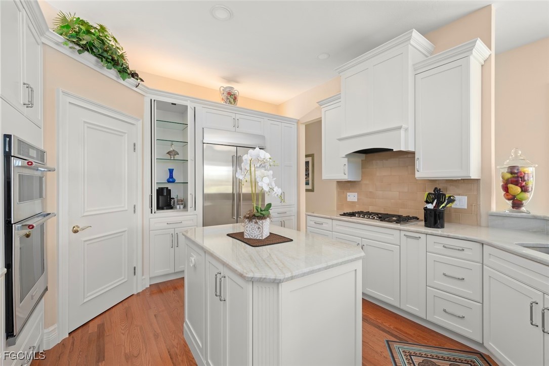 2417 Wulfert Road Sanibel, FL 33957 - Photo 26 of 50 a kitchen with white cabinets and appliances