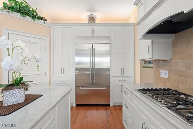 a kitchen with stainless steel appliances granite countertop a refrigerator and a stove